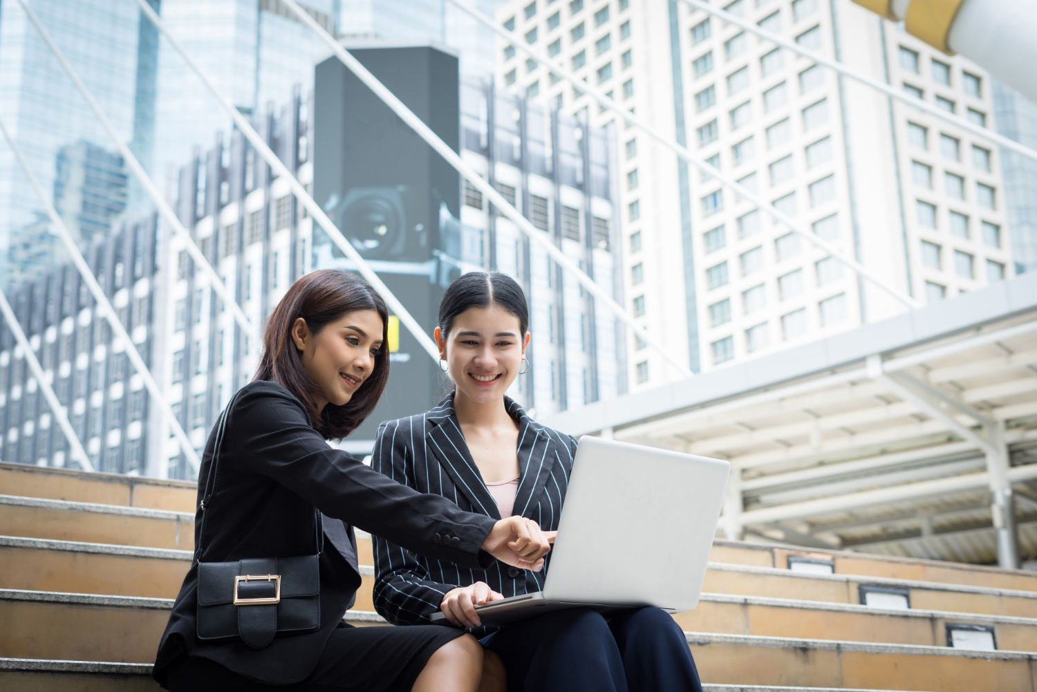 two businesswomen in front of a building